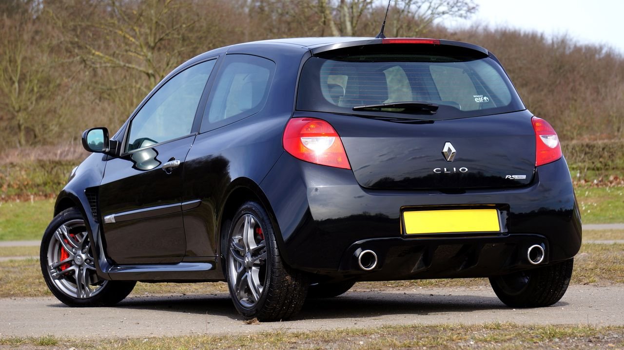 Black Renault Clio RS hot hatchback car parked outdoors surrounded by nature.
